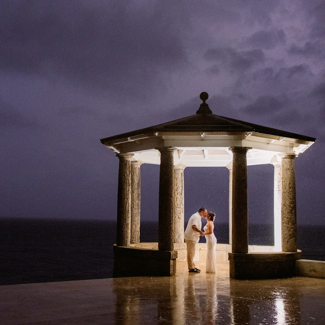 Pareja bajo un templete frente al mar